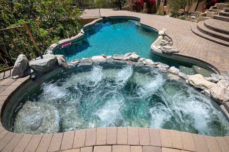 a Pool with a hot tub sitting above it